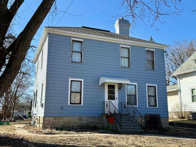 view of front facade with central air condition unit and a chimney