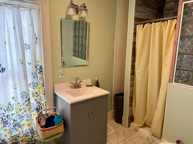 15 1st St SE, Faribault, MN 55021 - bathroom with curtained shower, vanity, and marble look tile flooring