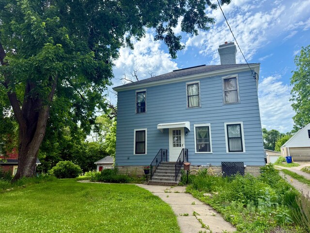 15 1st St SE, Faribault, MN 55021 - view of front facade with a chimney and a front lawn