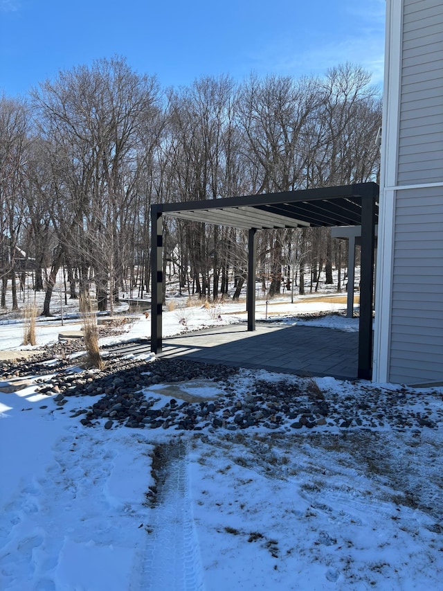 snowy yard with a carport