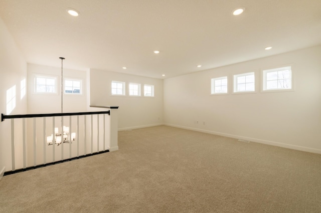 unfurnished room with recessed lighting, light colored carpet, a notable chandelier, and baseboards