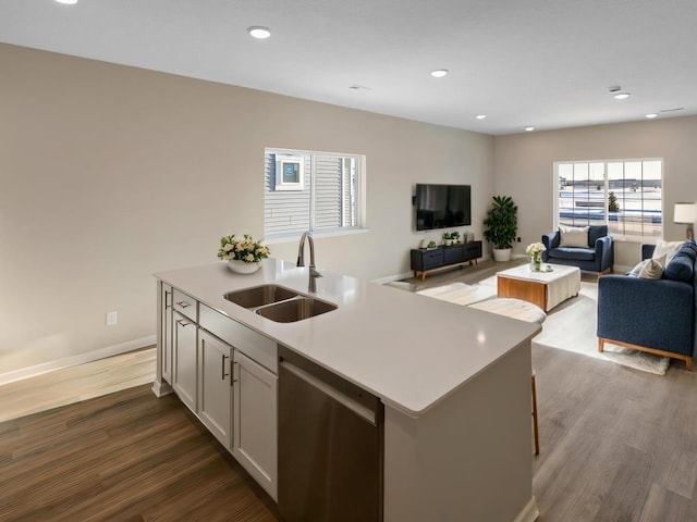 kitchen featuring a sink, dark wood-style flooring, open floor plan, and dishwasher