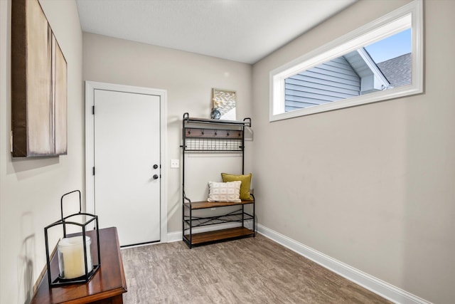 doorway featuring light wood-style flooring and baseboards