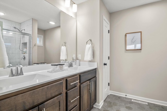 full bath with a stall shower, a sink, visible vents, and baseboards
