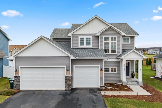 view of front of home with driveway and roof with shingles