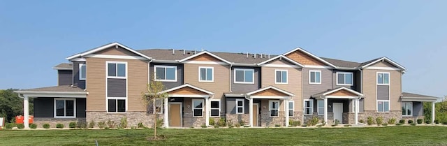 craftsman house with stone siding and a front yard