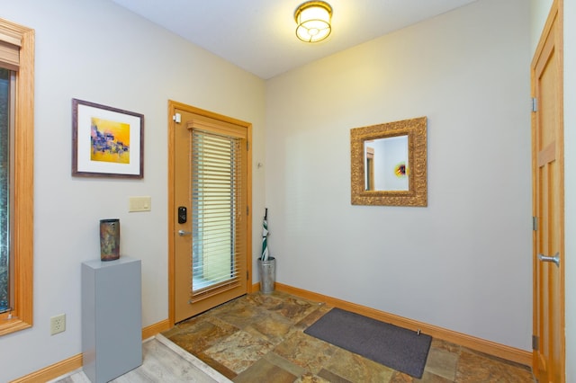 entryway with baseboards and stone finish floor