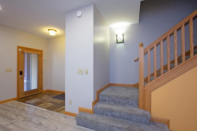 interior space featuring wood finished floors, baseboards, and stairs