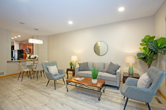 living area with recessed lighting, visible vents, and light wood-style flooring