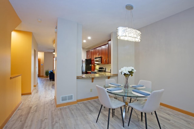 dining area featuring light wood finished floors, baseboards, visible vents, and recessed lighting