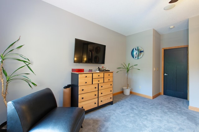 living area featuring baseboards and light colored carpet