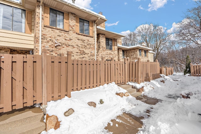 exterior space with fence and brick siding