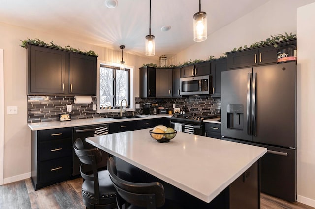 kitchen featuring a sink, vaulted ceiling, light countertops, and stainless steel appliances