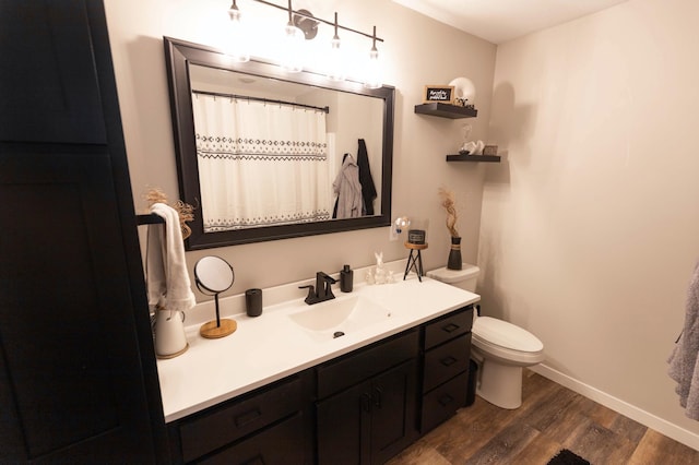 full bathroom with vanity, wood finished floors, baseboards, curtained shower, and toilet