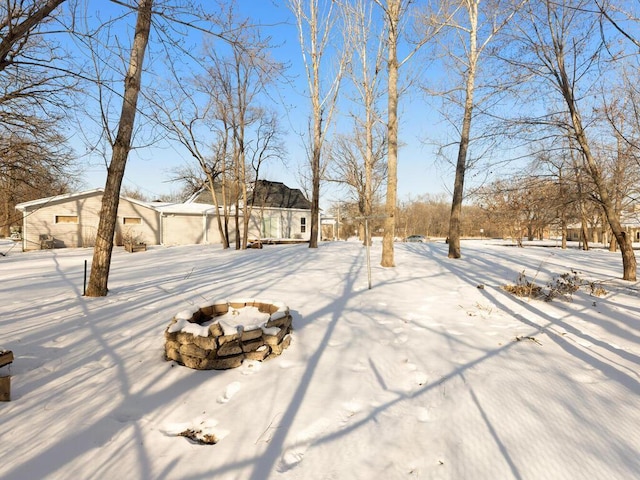 yard layered in snow with a fire pit