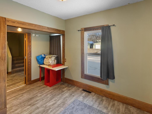 doorway to outside with stairway, wood finished floors, visible vents, and baseboards