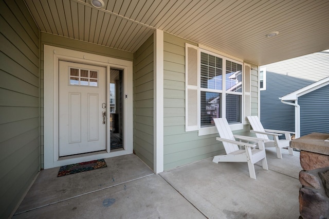 view of exterior entry featuring covered porch