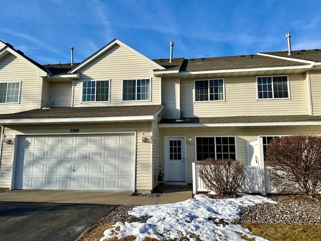 view of front of house featuring a garage, driveway, and roof with shingles