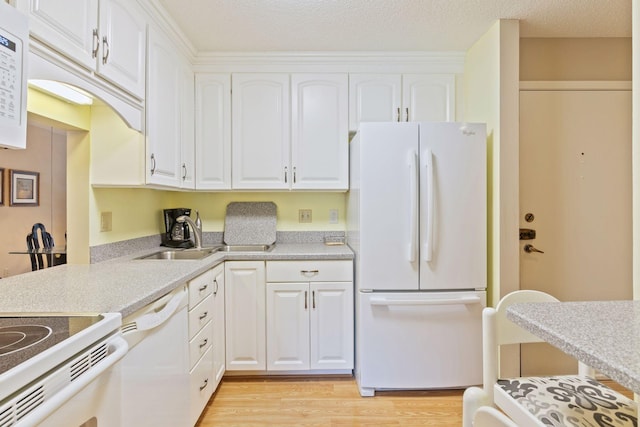 kitchen featuring light wood-type flooring, light countertops, white appliances, white cabinetry, and a sink