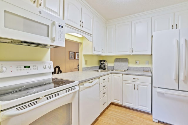 kitchen with white cabinetry, white appliances, light wood-style floors, and light countertops