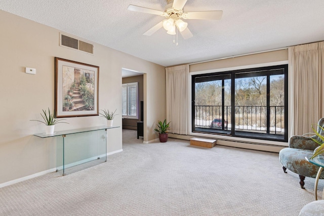 sitting room featuring visible vents, a textured ceiling, a healthy amount of sunlight, and carpet flooring