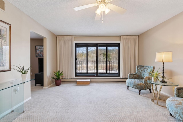 sitting room with visible vents, baseboards, carpet floors, ceiling fan, and a textured ceiling