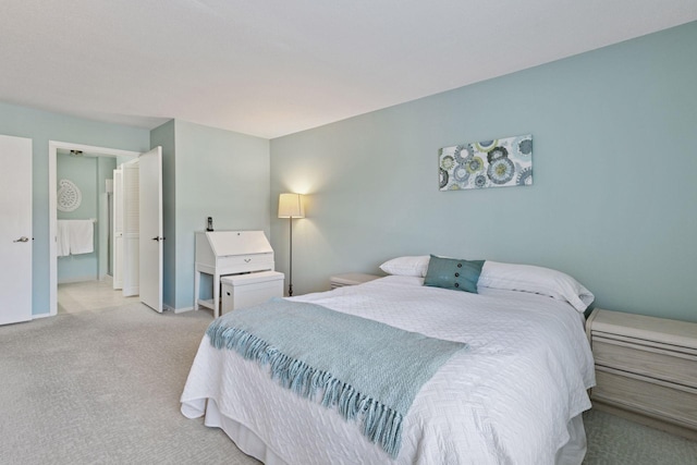 bedroom with baseboards and light carpet