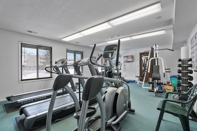 exercise room with visible vents and a textured ceiling