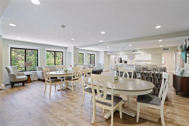 dining area with plenty of natural light, visible vents, and light wood-type flooring