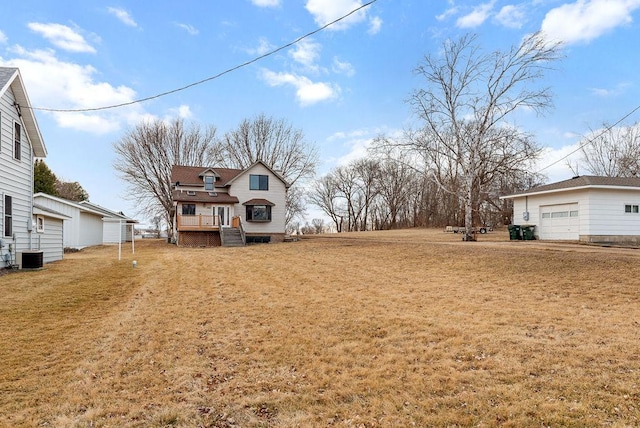 view of yard featuring an outbuilding, a garage, and central AC