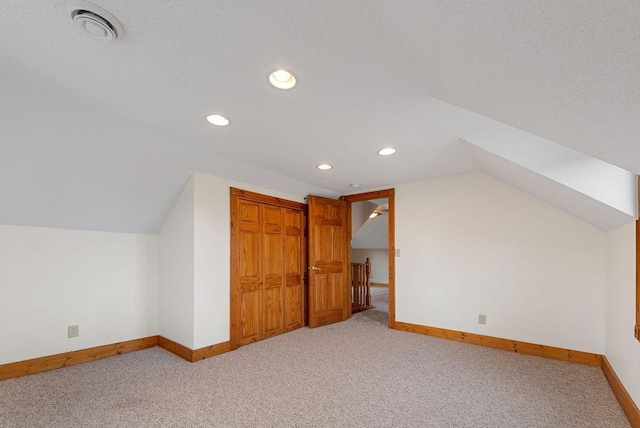 additional living space with visible vents, lofted ceiling, recessed lighting, carpet floors, and baseboards