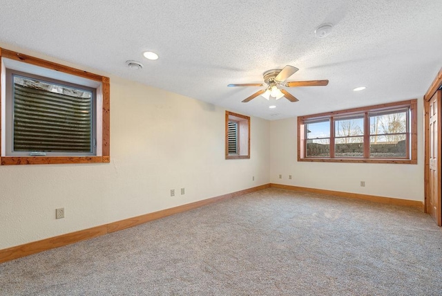 unfurnished room featuring baseboards, light carpet, a textured ceiling, and ceiling fan