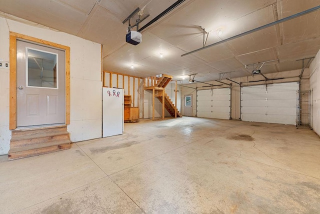 garage featuring a garage door opener and freestanding refrigerator