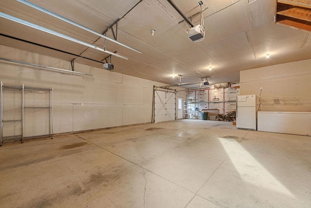 garage featuring a garage door opener and freestanding refrigerator