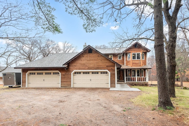 view of front of home with a chimney, a shingled roof, covered porch, a garage, and driveway