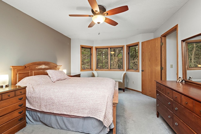 bedroom with a ceiling fan, light colored carpet, and baseboards