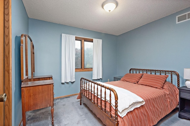 carpeted bedroom with a textured ceiling, visible vents, and baseboards