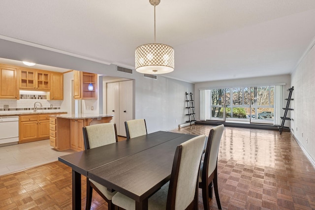 dining room with baseboards, visible vents, and ornamental molding