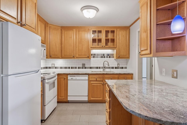 kitchen featuring white appliances, tasteful backsplash, light stone counters, open shelves, and a sink