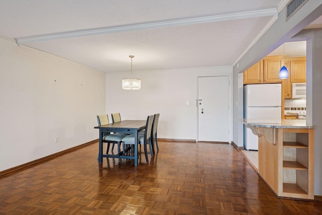 dining room with ornamental molding, visible vents, and baseboards