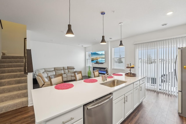 kitchen featuring dark wood-style floors, stainless steel appliances, a sink, and open floor plan