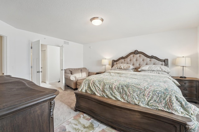 bedroom featuring a textured ceiling, visible vents, and light colored carpet