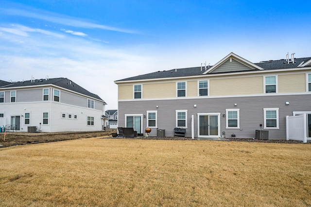 back of house featuring a lawn and central air condition unit