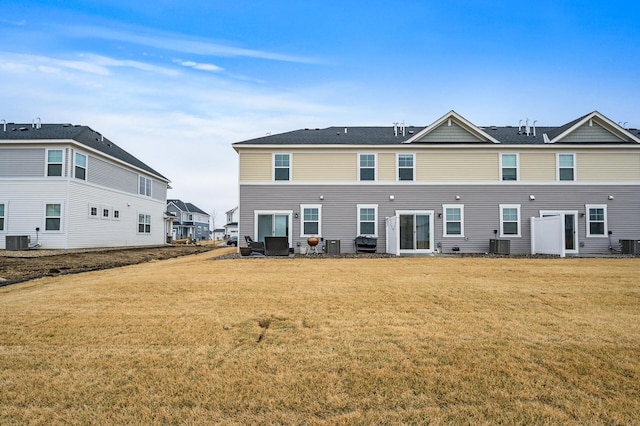 back of house featuring a yard and central air condition unit