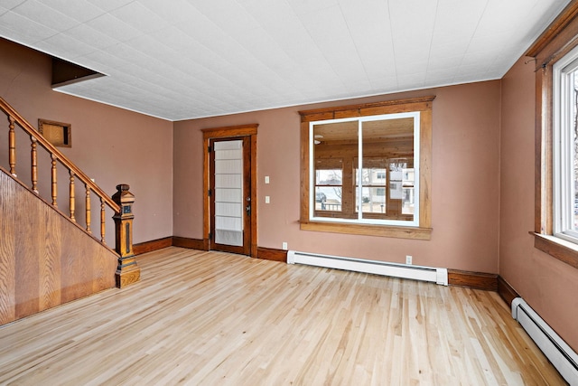 entrance foyer with stairway, a baseboard radiator, and wood finished floors