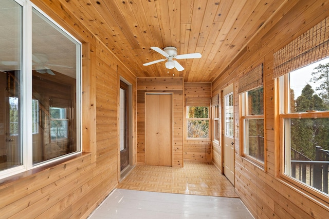 unfurnished sunroom with wooden ceiling and ceiling fan