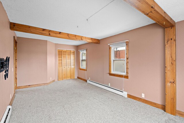 unfurnished bedroom featuring beam ceiling, a baseboard radiator, baseboard heating, carpet flooring, and baseboards