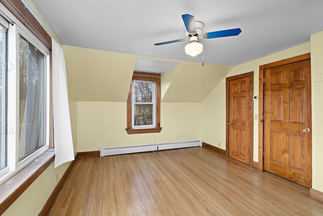 bonus room with vaulted ceiling, baseboard heating, wood finished floors, and baseboards