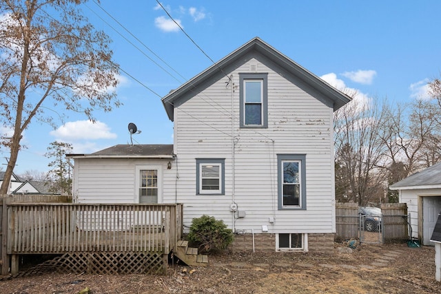 rear view of house with a gate, fence, and a deck