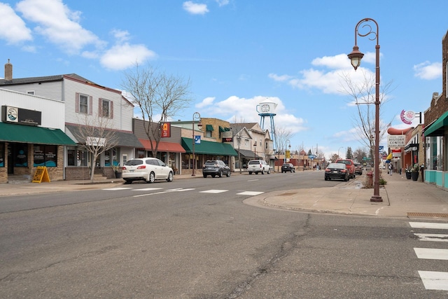 view of road featuring sidewalks, curbs, and street lights